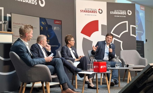 Podiumsdiskussion mit vier Personen zu Standards, mit einem Fokus auf Innovation.
