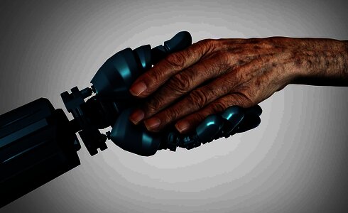 Eine menschliche Hand und eine Robotik-Hand halten sich.