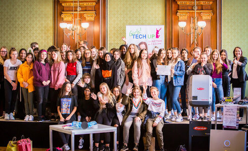 Gruppenselfie von Mädchen bei einem Technologie-Event mit Siegerurkunden.