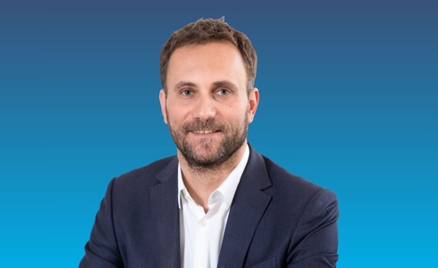 Porträt eines Mannes in Anzug mit lächelndem Gesicht.