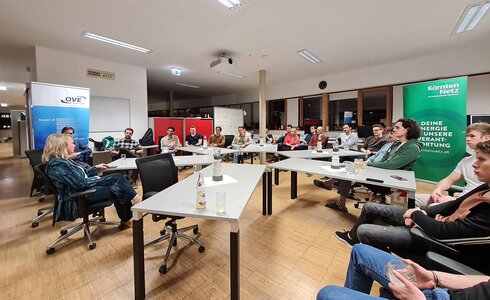 Eine Gruppe von Menschen sitzt in einem Besprechungsraum und diskutiert.