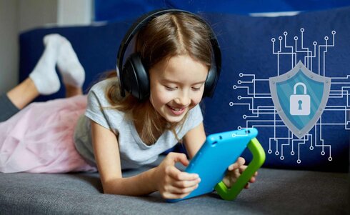 Ein Mädchen mit Kopfhörern spielt glücklich mit einem Tablet.