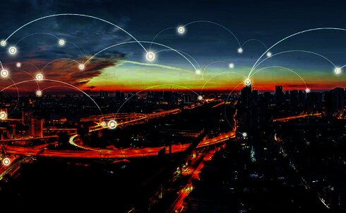 Stadtansicht mit Verkehrsnetz und digitalen Verbindungen beim Sonnenuntergang.