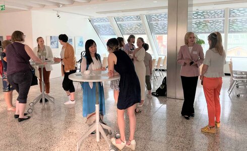 Gruppengespräch zwischen Menschen in einem hellen, modernen Raum.