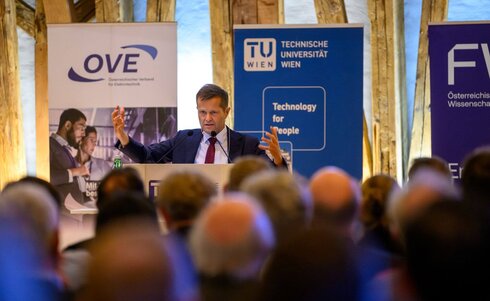 Ein Redner steht vor einem Publikum und präsentiert Konzepte zur Technologie für Menschen.