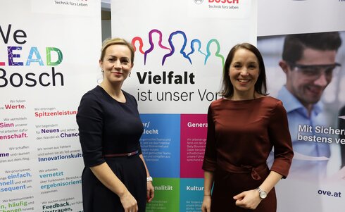 Zwei Frauen stehen vor Bannern, die Vielfalt und Werte bei Bosch betonen.