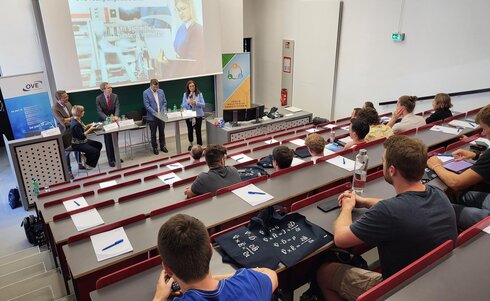 Podiumsdiskussion mit Referenten vor Publikum in einem Hörsaal.
