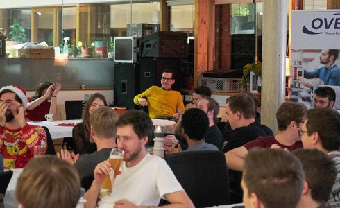 Junge Leute feiern in einem ungezwungenen Umfeld, mit Getränken und guter Stimmung.