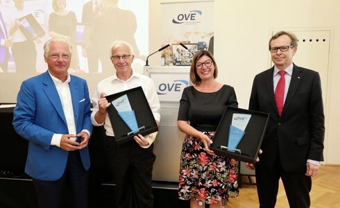 Vier Personen halten Auszeichnungen bei einer Veranstaltung.