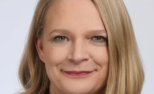 Ein Porträt einer Frau mit blonden Haaren und einem freundlichen Lächeln.