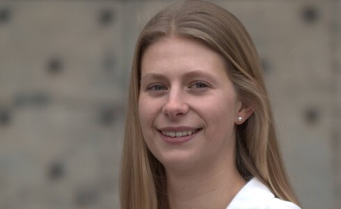 Junge Frau mit langen Haaren lächelt freundlich in die Kamera.