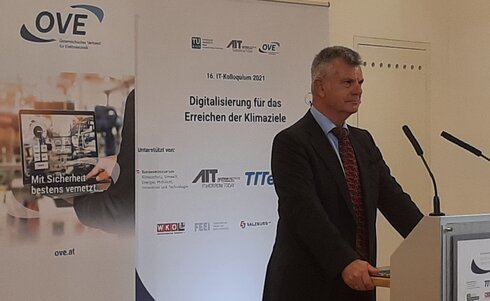 Ein Mann spricht auf einer Konferenz zur Digitalisierung und Klimazielen.