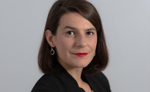 Porträt einer Frau mit kurzen, braunen Haaren und roten Lippen.