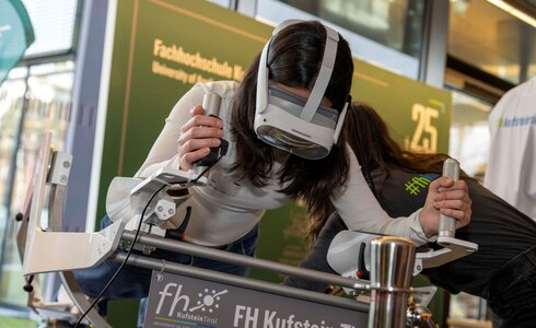 Eine Person testet virtuell eine Technologie mit einer VR-Brille an einem Gerät.