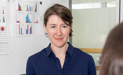 Eine Frau spricht mit jemandem über Grafiken und Diagramme.