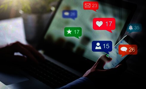 Eine Person nutzt ein Smartphone, während Benachrichtigungen über soziale Medien angezeigt werden.