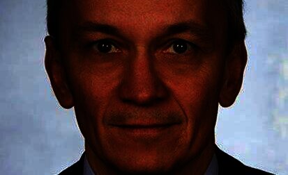 Porträt eines Mannes in Anzug mit neutralem Ausdruck.