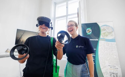 Zwei Frauen erleben Virtual Reality und lachen dabei.
