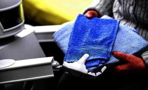 Eine Person hält mehrere blaue Handtücher in der Hand.