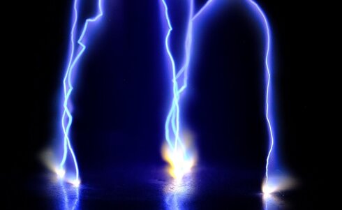 Blaues Licht des Blitzes, der über dunklem Hintergrund zu sehen ist.