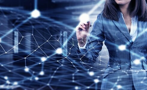 Eine Frau in einem Anzug interagiert mit einem digitalen Netzwerk.