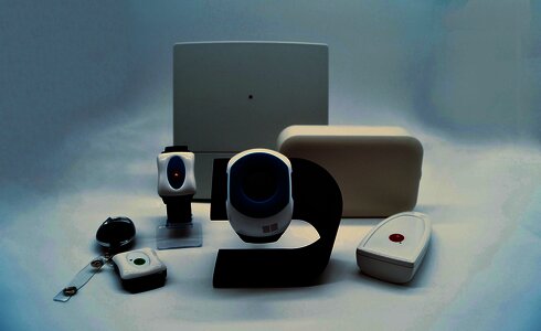 Verschiedene elektronische Geräte, darunter Uhren und Notrufsysteme, auf einem weißen Hintergrund.