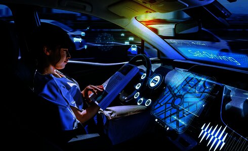 Eine Frau liest in einem autonom fahrenden Auto. Moderne Technologie um sie herum.
