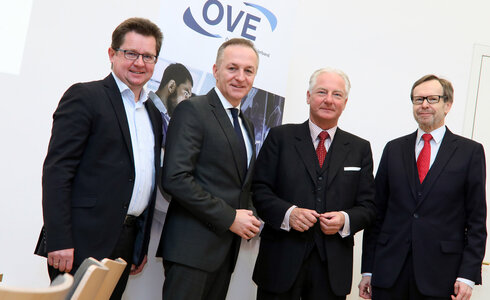 Vier Männer stehen zusammen, lächeln und posieren für ein Foto.